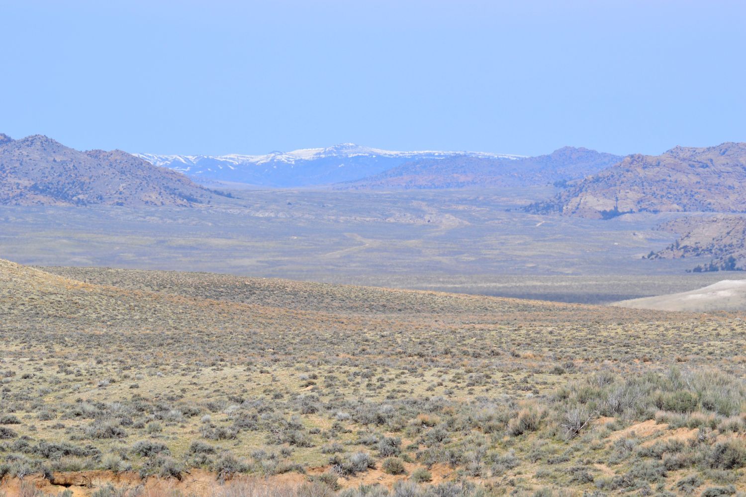 Open sagebrush flats running toward the notched granite ridge of Split Rock on the horizon.